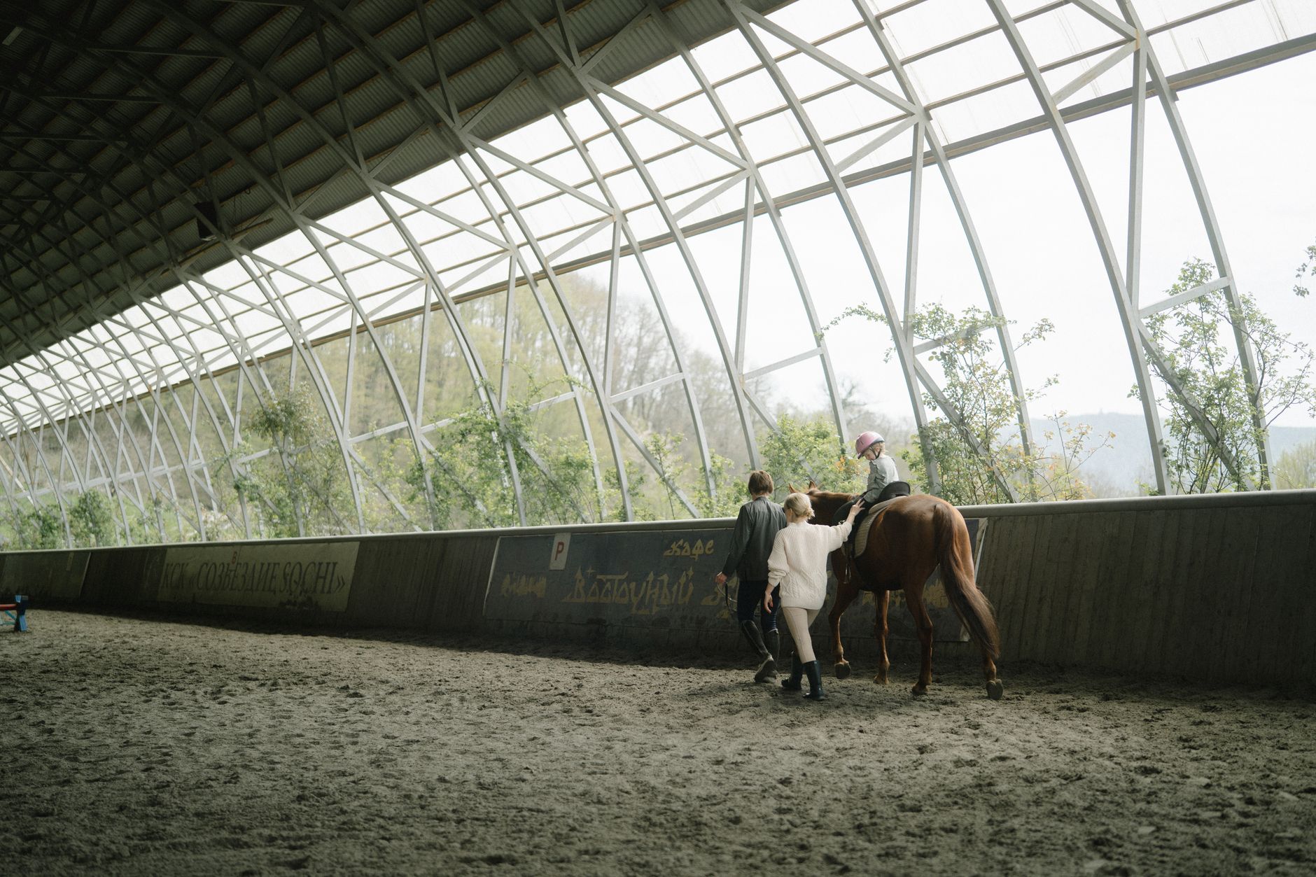 Young rider receiving instruction in equestrian arena